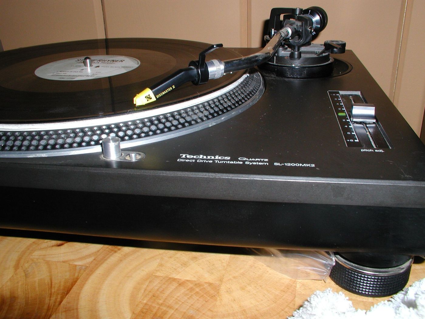 A black Technics turntable with a record on the platter